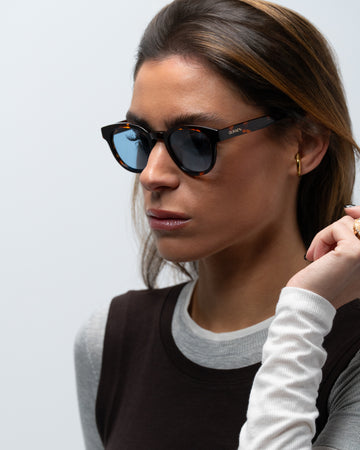 Milo Havana round sunglasses blue lenses woman wearing 